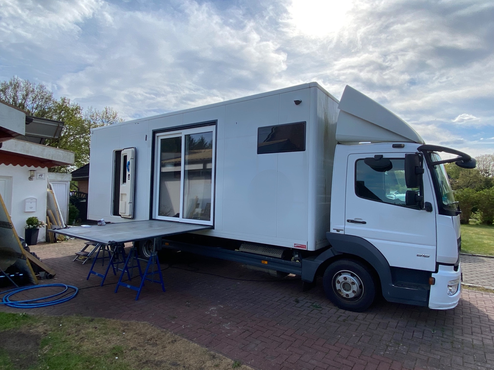 Mercedes Atego 818 Hopsie im Ausbaustand mit großer zweiflügeliger Schiebetür am Wohnkoffer.